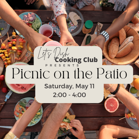 hands reaching across a picnic table with various dishes